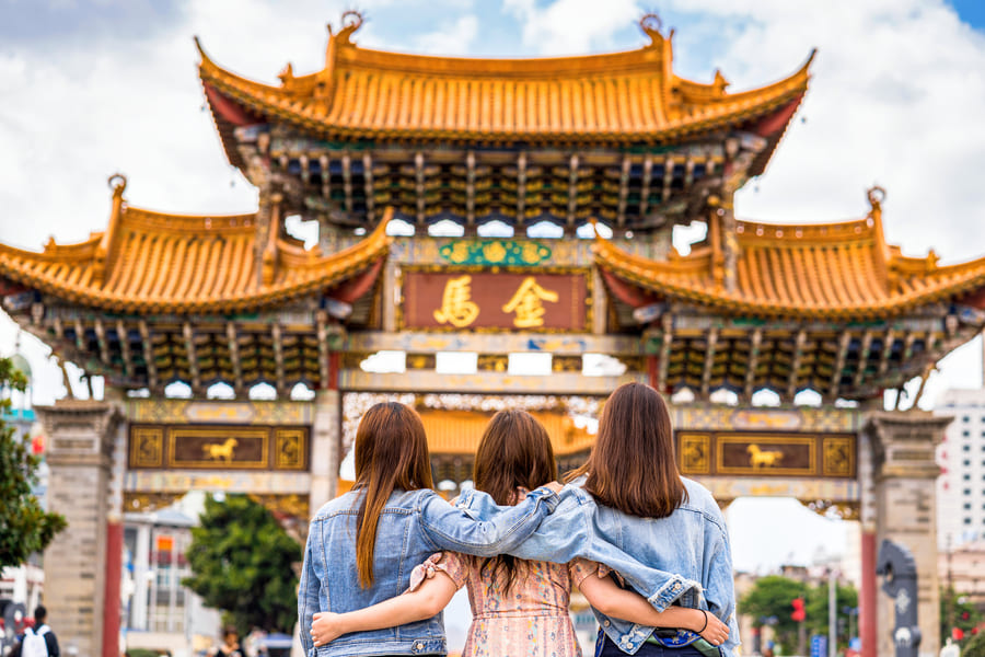 tres mujeres abrazadas de frente mirando al templo chino vacaciones familiares